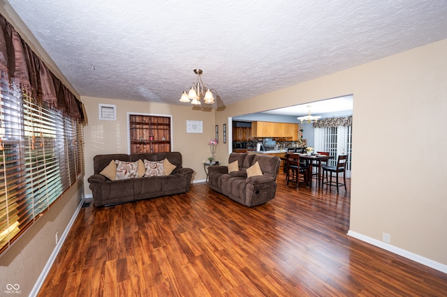 living room featuring dark hardwood / wood-style flooring, a notable chandelier, and a textured ceiling