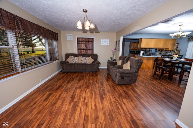 living room with dark hardwood / wood-style flooring, an inviting chandelier, and a textured ceiling