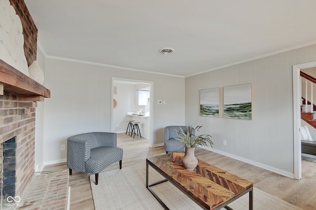 living area with a fireplace, light wood-type flooring, and crown molding