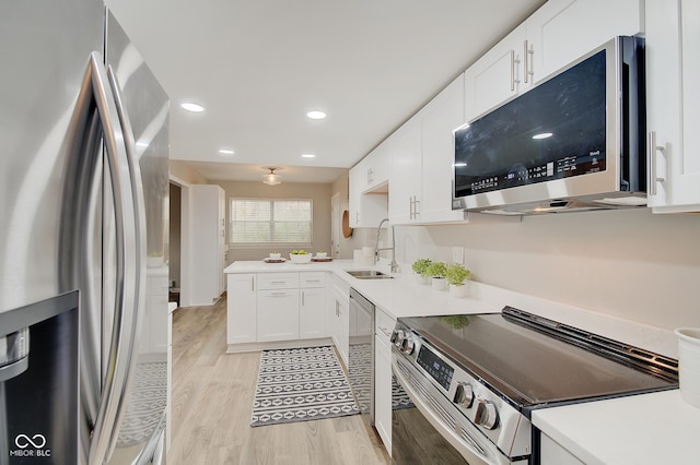 4902 N Capitol Ave, Indianapolis, IN 46208 - kitchen with stainless steel appliances, a sink, light wood finished floors, white cabinets, and recessed lighting