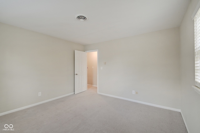 spare room featuring light colored carpet