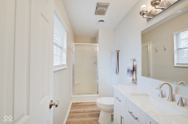 bathroom featuring walk in shower, hardwood / wood-style floors, vanity, and toilet