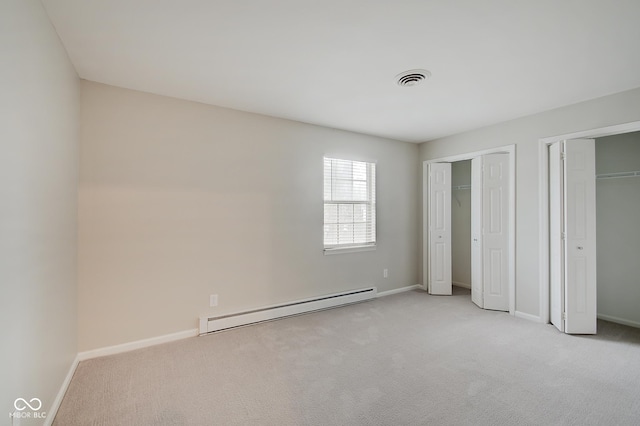 4902 N Capitol Ave, Indianapolis, IN 46208 - unfurnished bedroom featuring a baseboard radiator, two closets, carpet, and baseboards