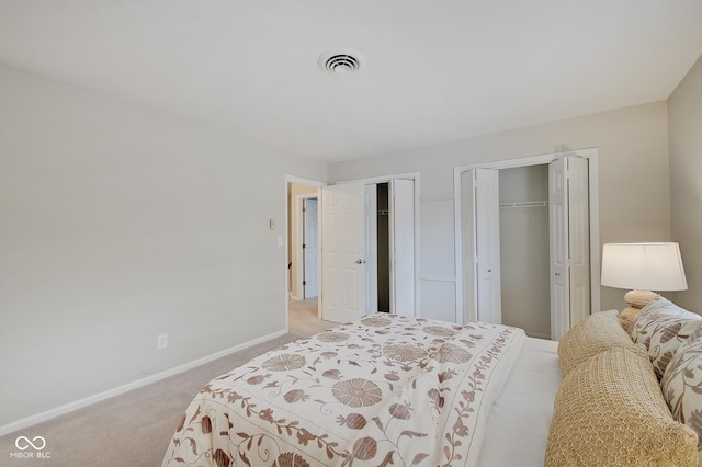 4902 N Capitol Ave, Indianapolis, IN 46208 - bedroom featuring multiple closets, light carpet, and baseboards