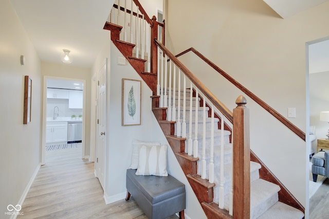 stairway featuring hardwood / wood-style flooring and sink