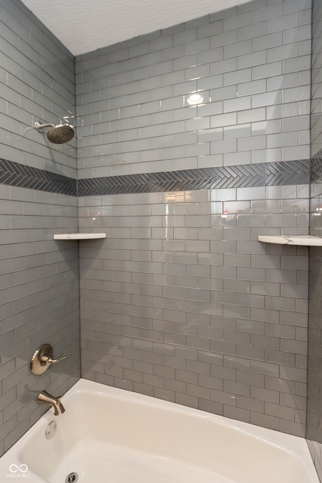 bathroom featuring tiled shower / bath