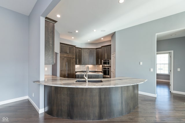 kitchen featuring kitchen peninsula, dark wood-type flooring, paneled built in fridge, and sink