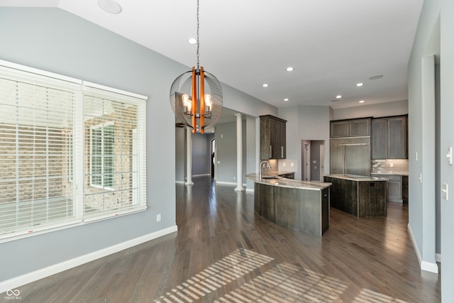 kitchen with ornate columns, sink, a center island, dark hardwood / wood-style floors, and hanging light fixtures