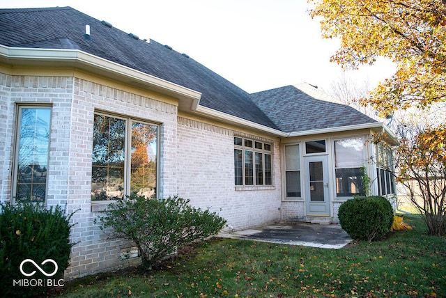 rear view of property featuring a lawn and a patio