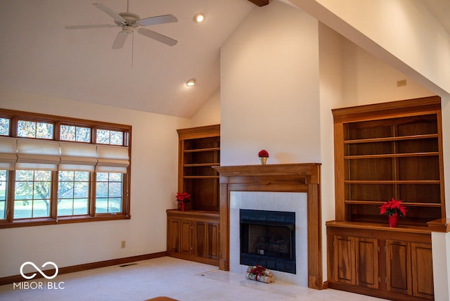 unfurnished living room with a tile fireplace, ceiling fan, high vaulted ceiling, and light carpet