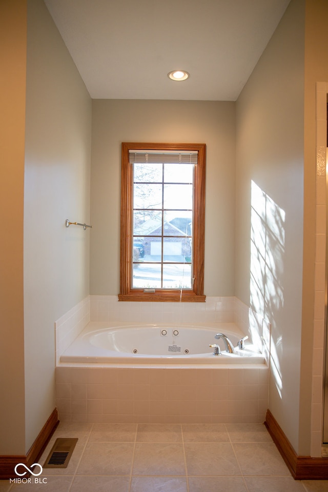 bathroom with tile patterned floors and a relaxing tiled tub