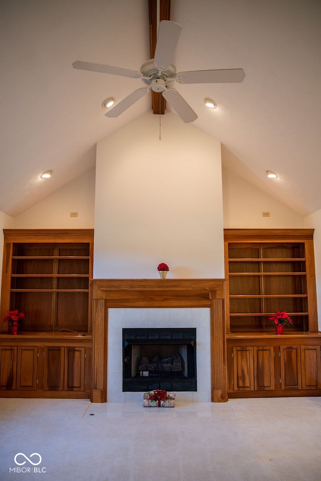 unfurnished living room featuring a tile fireplace, ceiling fan, light colored carpet, and vaulted ceiling