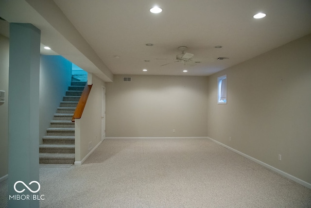 basement with ceiling fan and light carpet