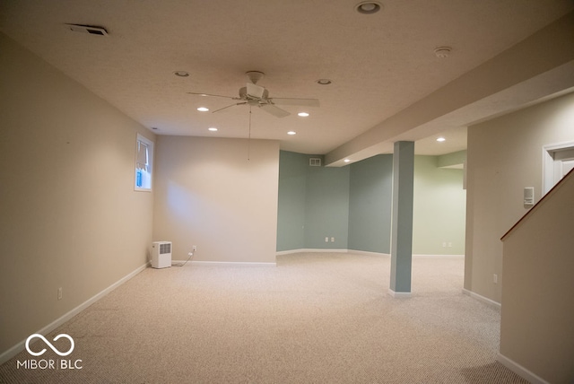 basement featuring light carpet and ceiling fan