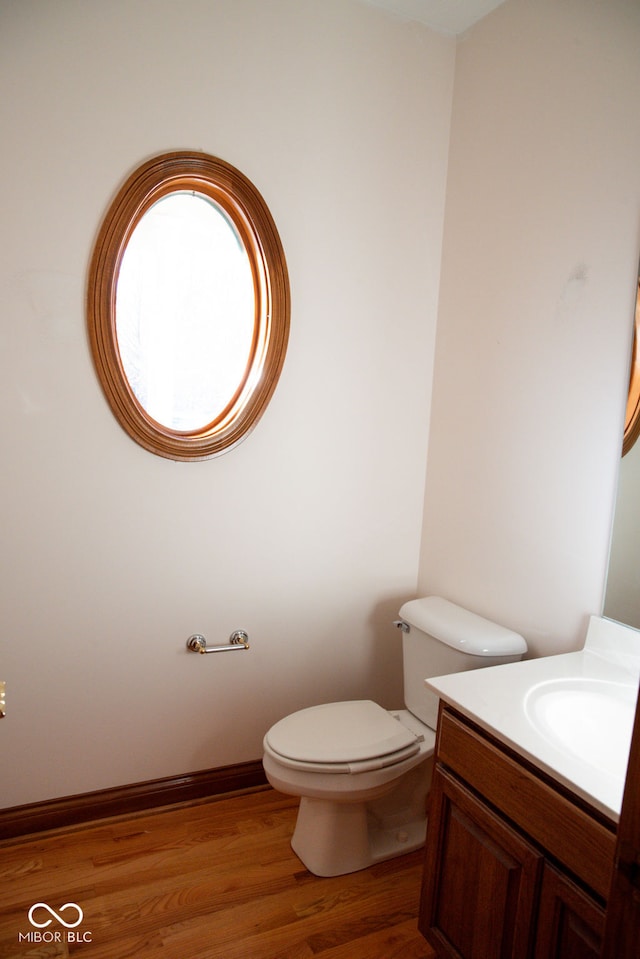 bathroom featuring vanity, hardwood / wood-style flooring, and toilet