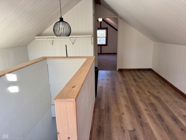 bonus room with dark hardwood / wood-style flooring, lofted ceiling, and wood walls