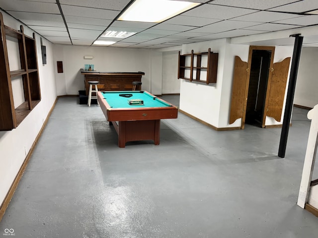 playroom with a paneled ceiling, concrete flooring, and pool table