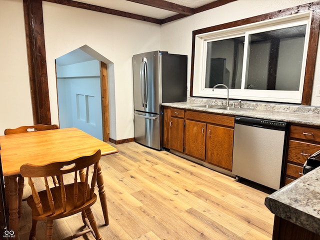 kitchen with beam ceiling, light wood-type flooring, stainless steel appliances, and sink