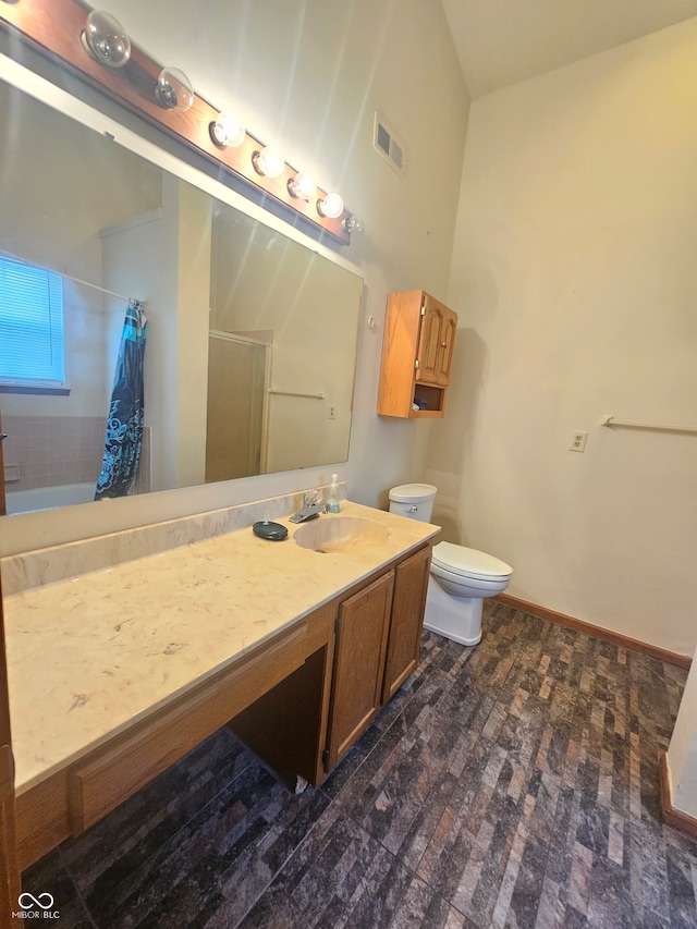 bathroom with walk in shower, vanity, and toilet