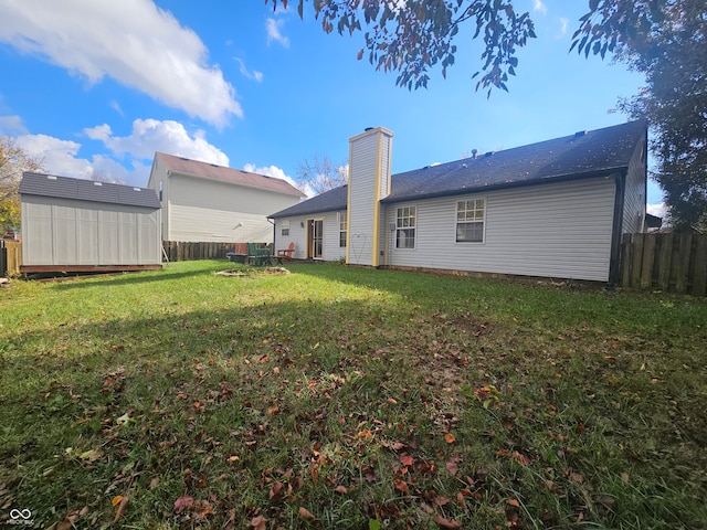 back of property featuring a storage unit and a yard