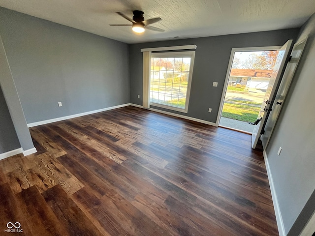 empty room with ceiling fan and dark wood-type flooring