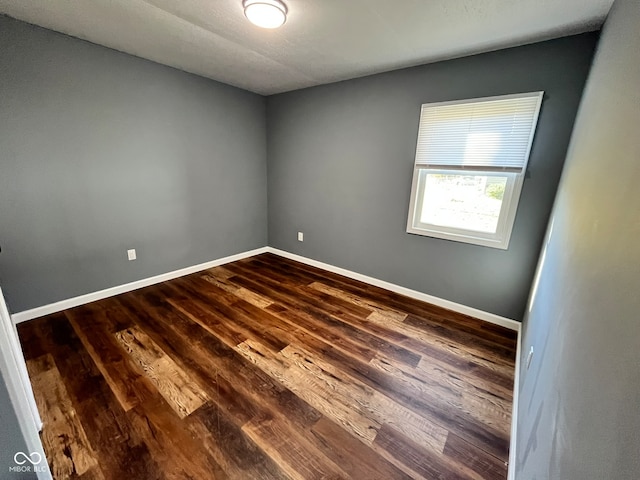 empty room with dark hardwood / wood-style floors