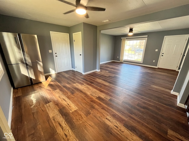 unfurnished living room with ceiling fan and dark wood-type flooring