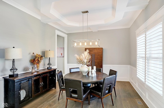 dining area featuring a raised ceiling, crown molding, and hardwood / wood-style flooring