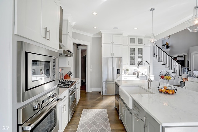 kitchen with hanging light fixtures, an island with sink, dark hardwood / wood-style flooring, white cabinetry, and stainless steel appliances