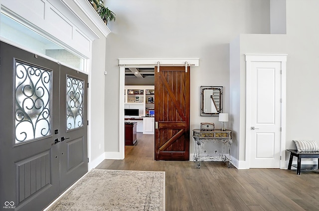 entryway with a barn door and dark hardwood / wood-style flooring