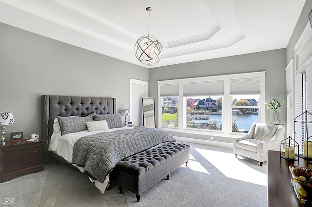 bedroom with carpet, a water view, and an inviting chandelier