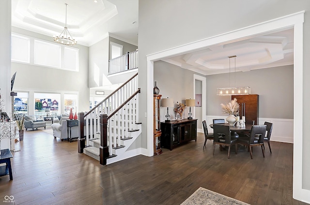 interior space featuring a chandelier, a tray ceiling, and dark hardwood / wood-style floors