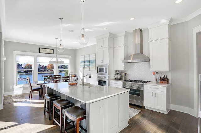 kitchen with white cabinetry, a kitchen island with sink, stainless steel appliances, and wall chimney range hood