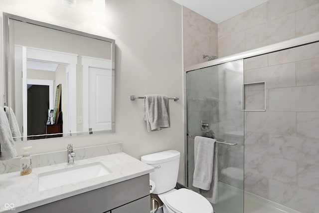 bathroom featuring toilet, vanity, and walk in shower