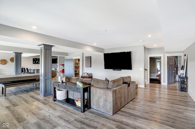 living room with ornate columns and light hardwood / wood-style flooring