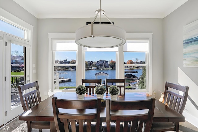 dining area with a water view and a healthy amount of sunlight