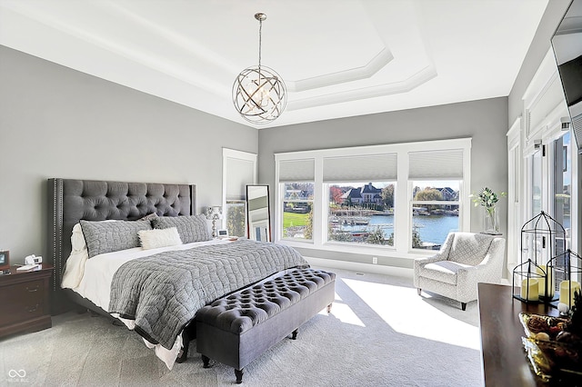 carpeted bedroom with a water view and an inviting chandelier