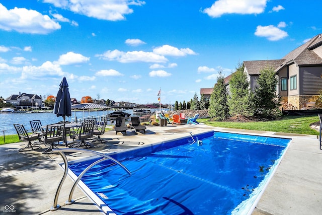 view of pool with a water view and a patio