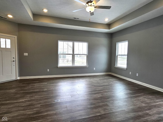 entrance foyer with ceiling fan, dark wood-type flooring, and a raised ceiling