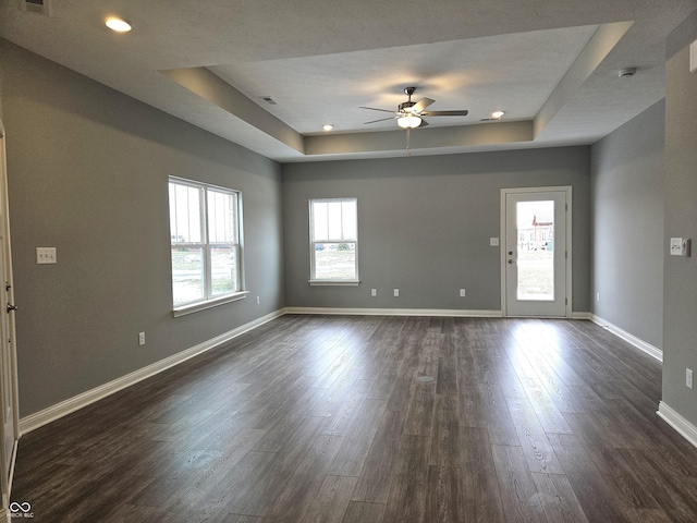 interior space featuring ceiling fan, a raised ceiling, and dark hardwood / wood-style floors