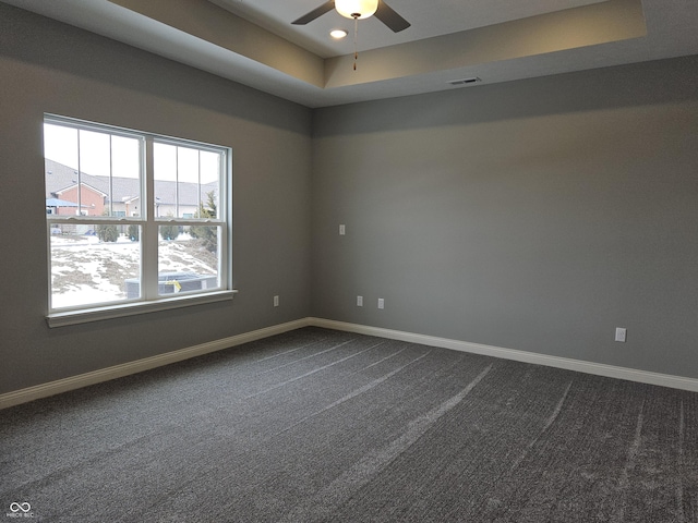 unfurnished room featuring ceiling fan, carpet, and a tray ceiling