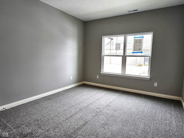 carpeted empty room featuring a textured ceiling