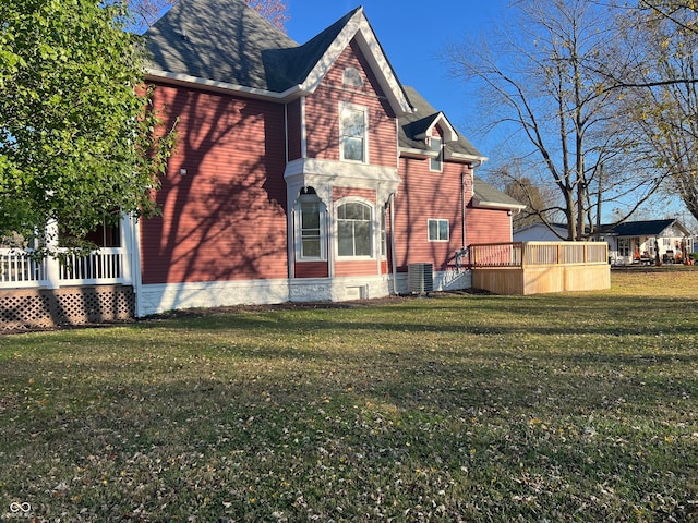 view of side of home with a yard and a deck