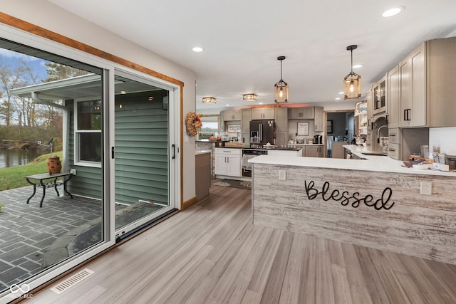 kitchen featuring stainless steel fridge, plenty of natural light, and light hardwood / wood-style flooring