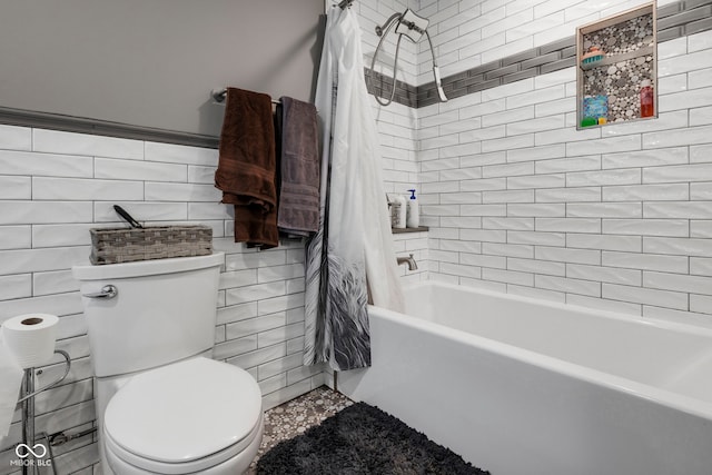 bathroom featuring shower / bathtub combination with curtain, toilet, and tile walls