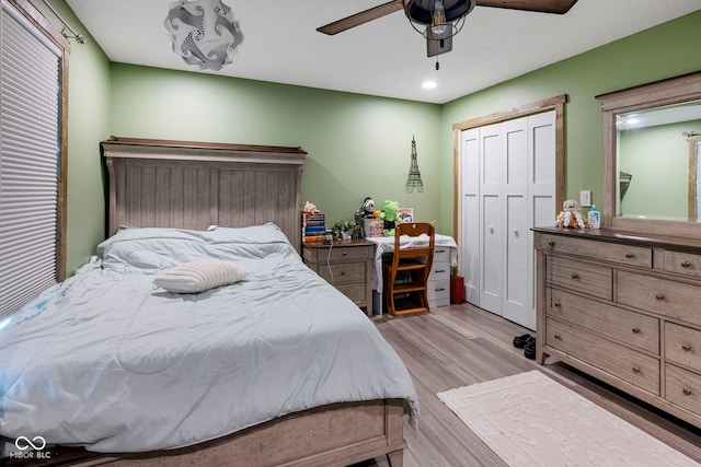 bedroom with a closet, light hardwood / wood-style flooring, and ceiling fan