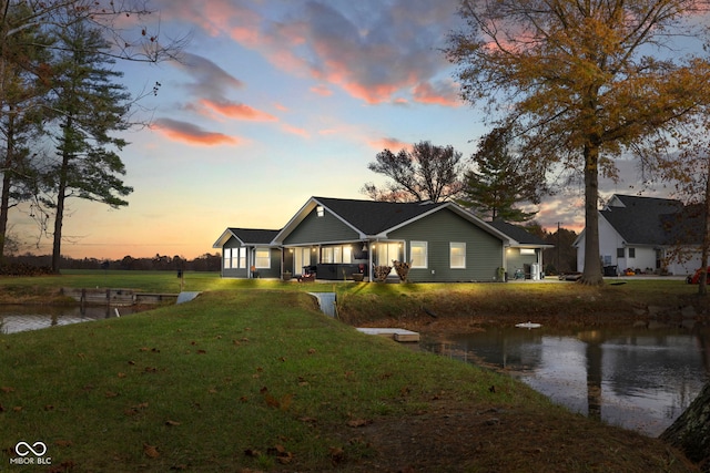 single story home with a water view and a yard