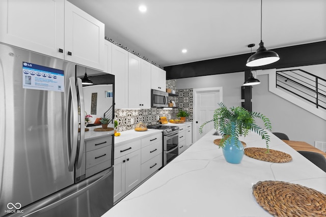 1514 E 12th St, Indianapolis, IN 46201 - kitchen featuring stainless steel appliances, tasteful backsplash, white cabinets, pendant lighting, and light stone counters