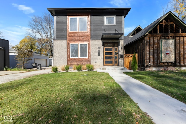 view of front of home with a garage, a front lawn, and an outdoor structure