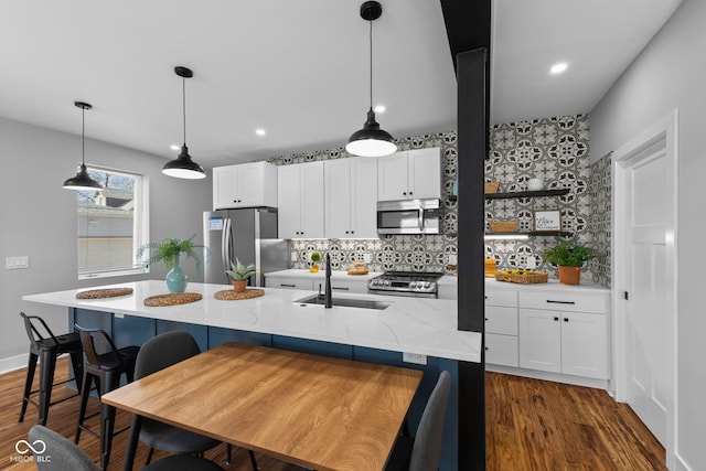 1514 E 12th St, Indianapolis, IN 46201 - kitchen with stainless steel appliances, a sink, decorative backsplash, dark wood-style floors, and white cabinets